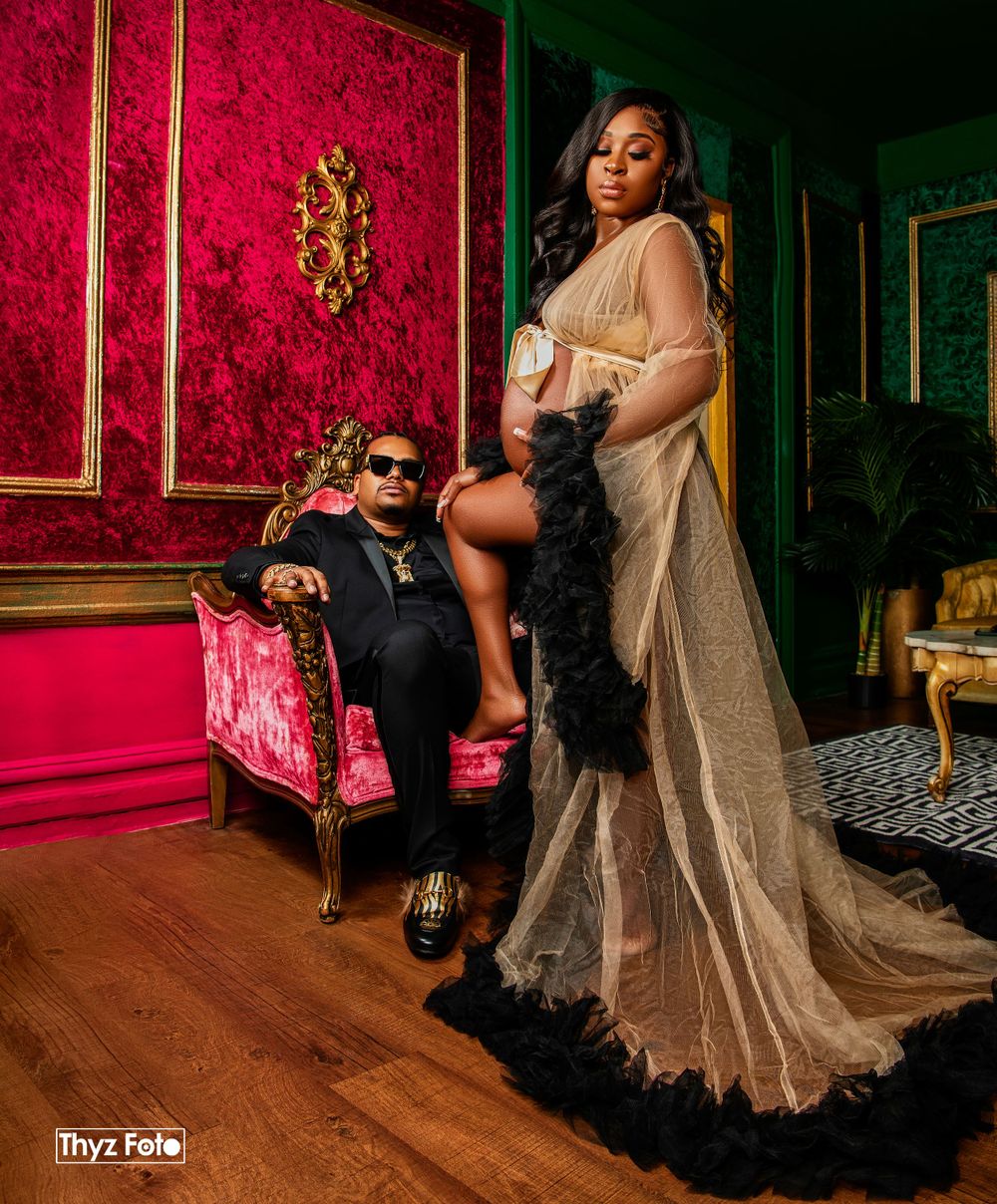 Luxury fashion editorial portrait featuring an elegantly dressed woman in a vintage, red-themed lounge.