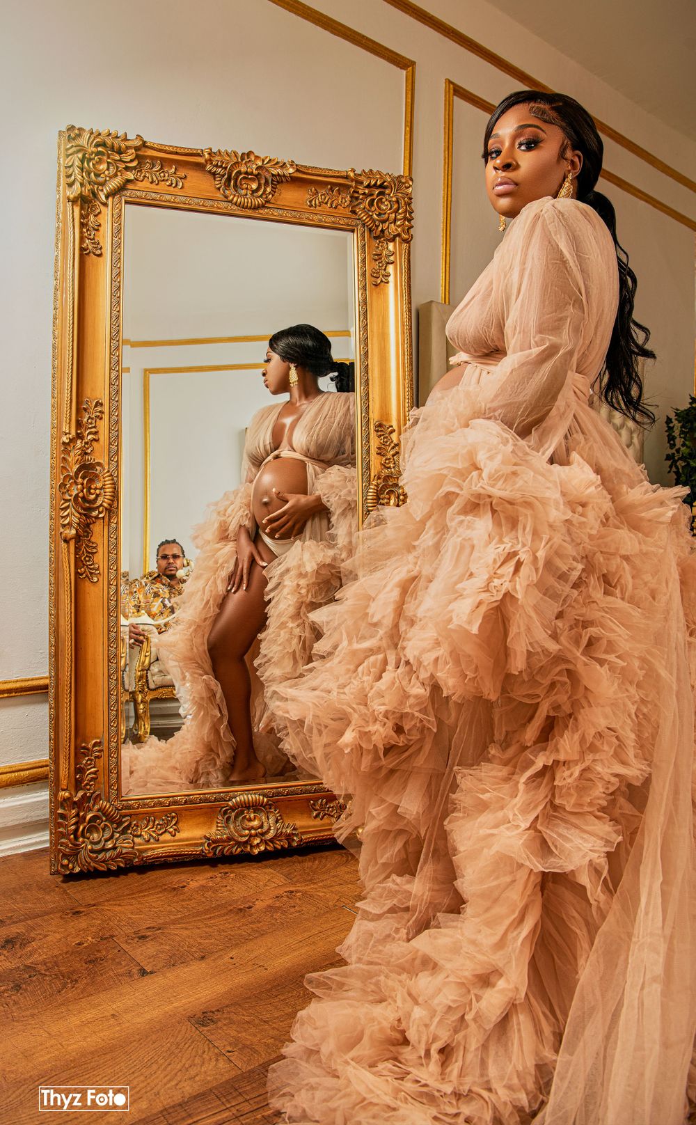 Sophisticated maternity portrait of an expecting mother in a luxurious, gold-themed setting.