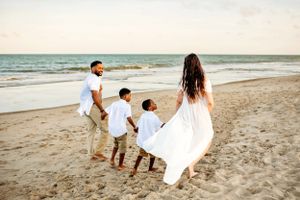 Family captures cherished walks on the beach.