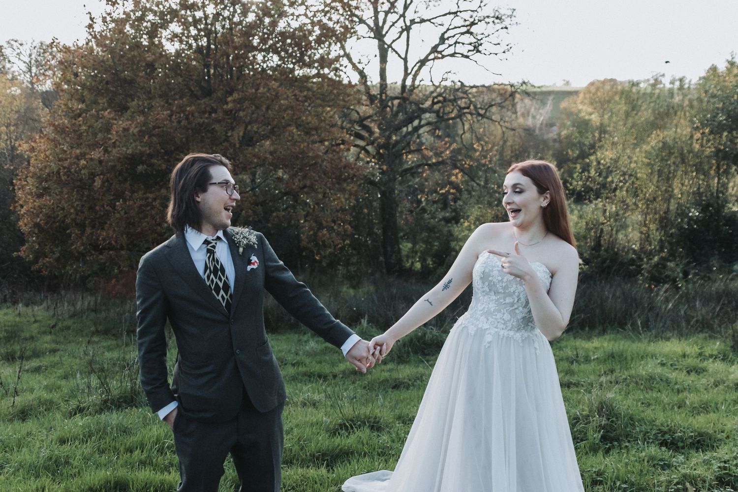 Bride and Groom pulling faces at each other in a field