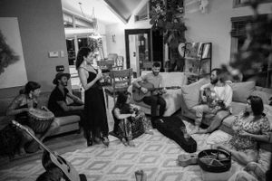 Black and white indoor gathering showing people socializing in a casual home setting.