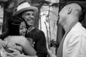 A candid black and white photo captures a joyful moment between friends sharing laughter.