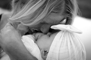 An intimate black and white portrait capturing a tender moment between parent and child.