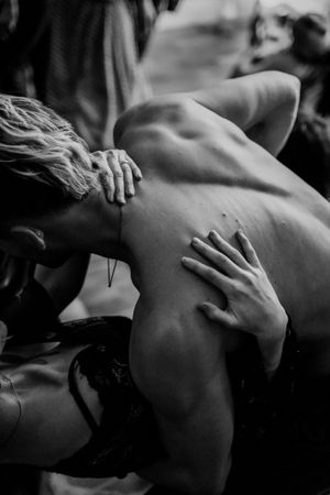 Intimate black and white photograph showing close physical connection between two people.