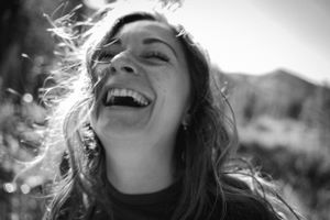 Black and white portrait of a joyful laugh captured in bright sunlight.