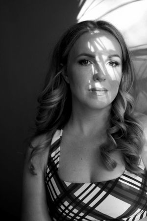 Dramatic black and white portrait with soft lighting and geometric patterned dress.