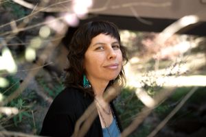 Natural light portrait with dappled sunlight through trees.