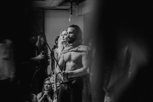 Dramatic black and white photo of a performer singing on stage.