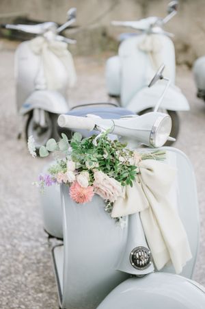 Vintage Vespa scooters decorated with delicate floral arrangements in pastel colors.