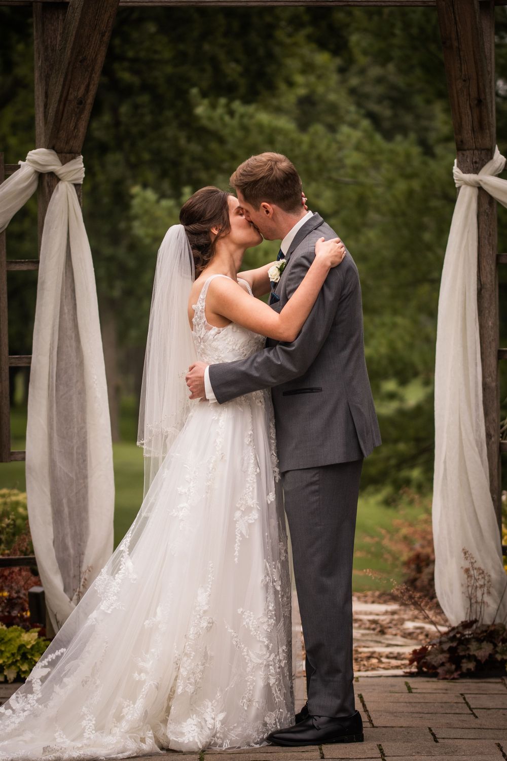 Bride and groom first kiss outdoor wedding ceremony at Stratford Country Club