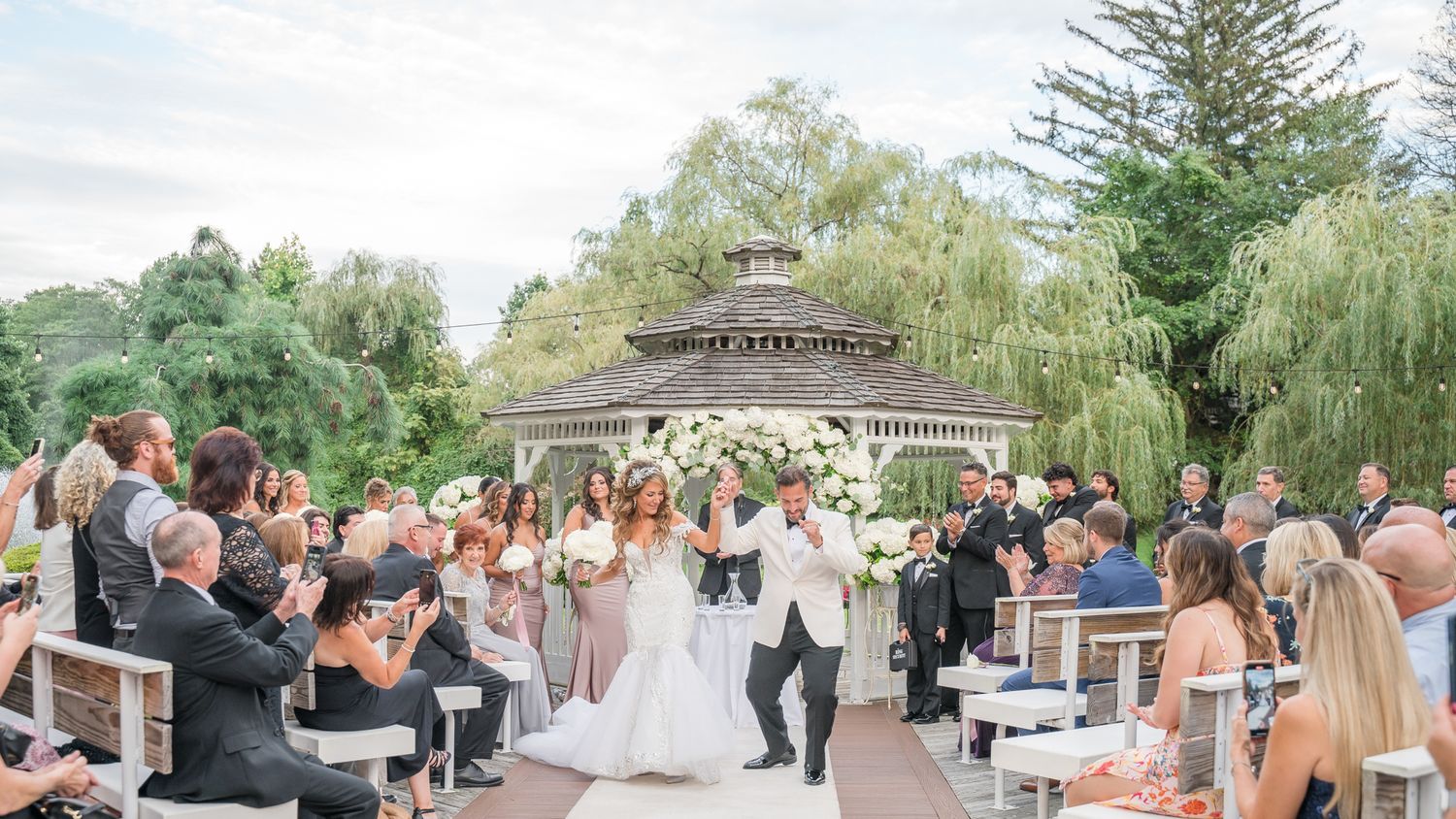 Newlyweds dance out of their outdoor ceremony at Flowerfield celebrating.