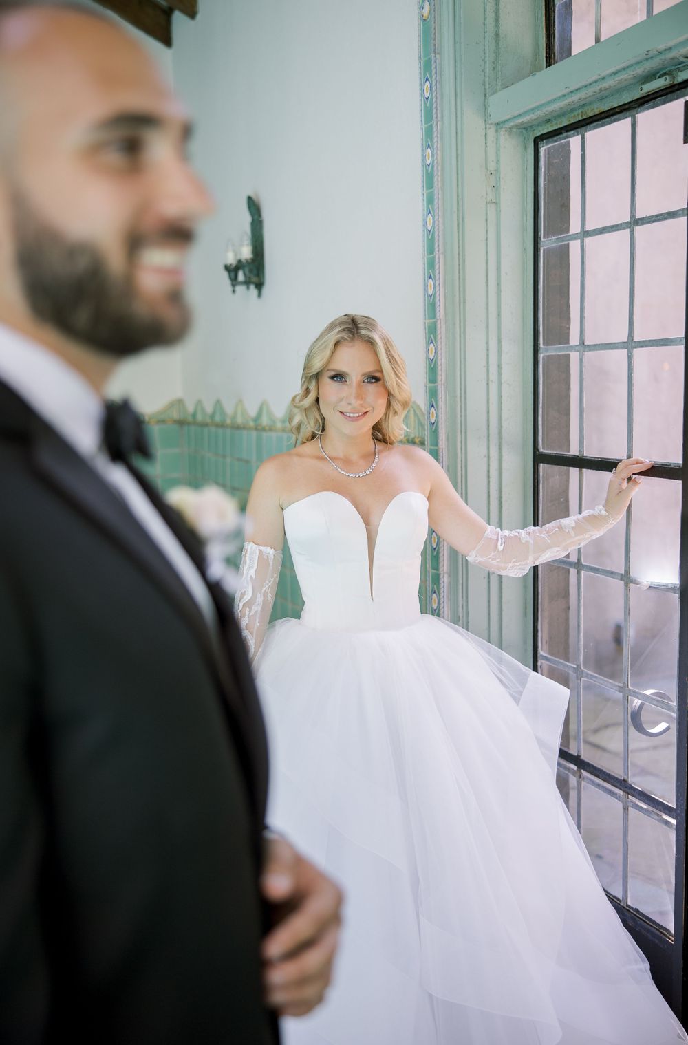 A wedding scene in a historic venue with ornate columns and decorative tilework.