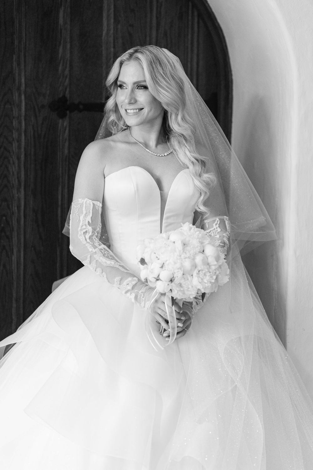 An elegant bridal portrait showcasing a strapless ballgown wedding dress with lace details.
