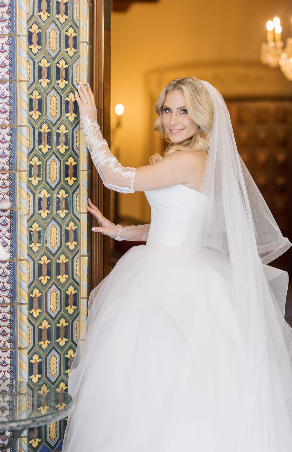 A bridal portrait featuring intricate tile work and warm lighting in a Spanish-style venue.