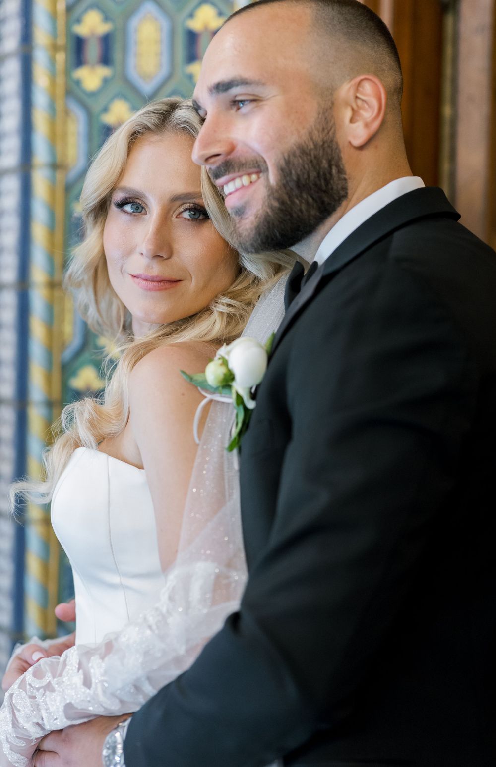 A joyful wedding portrait featuring decorative Moorish tiles and architecture.