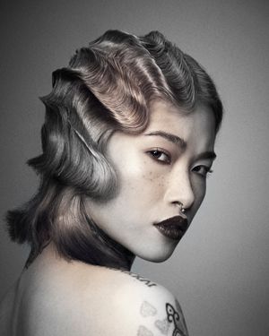 Modern finger wave hairstyle on Oriental girl. Black and white hair photo.