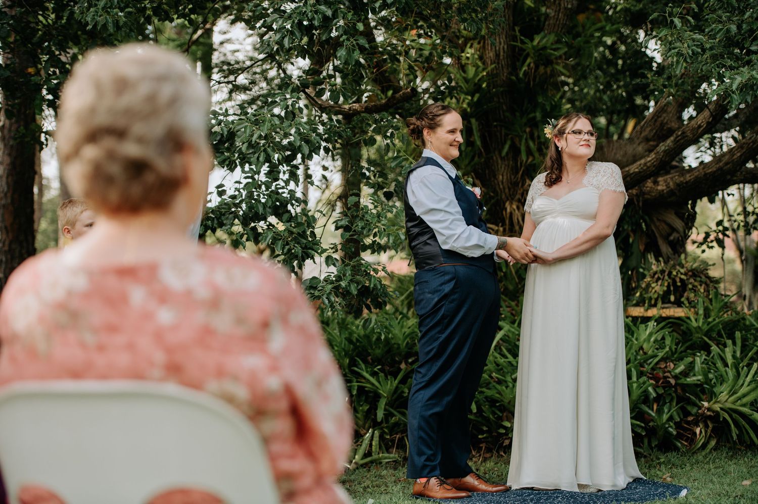 A garden wedding ceremony with natural greenery and trees creating a beautiful backdrop.