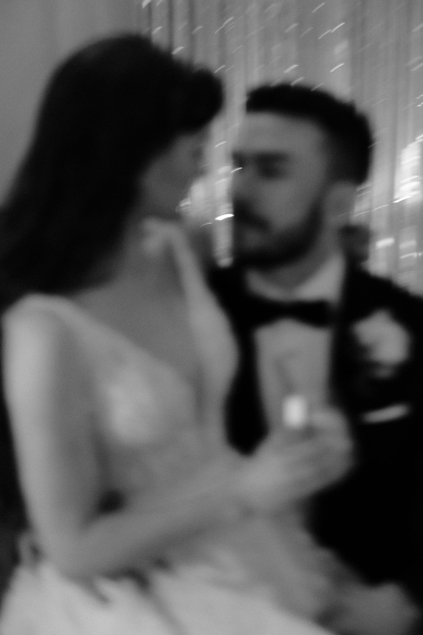 Artistic blurred black and white photo of bride and groom sharing an intimate moment during their wedding dance.