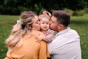 An intimate outdoor family portrait filled with joy and laughter in a flowery meadow.