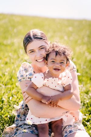 A joyful outdoor portrait in a sunny meadow with flowers.