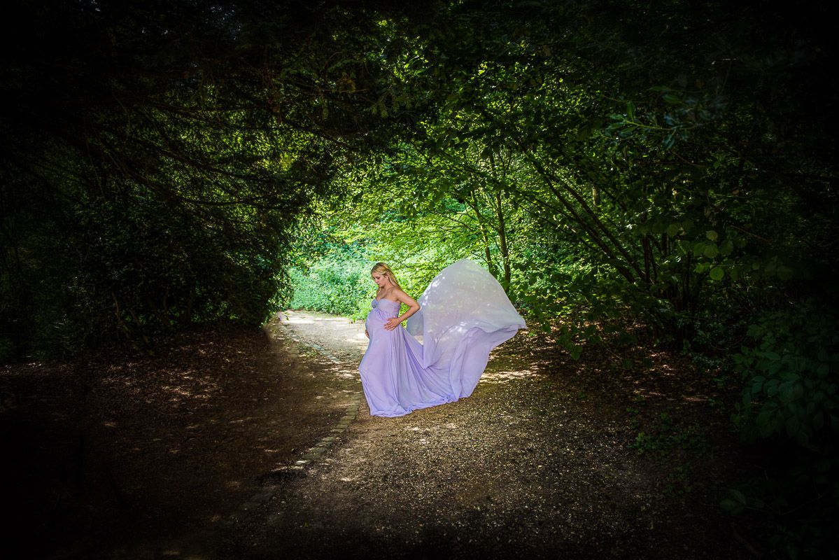 een foto van een zwangere vrouw tijdens een fotoreportage in het groen