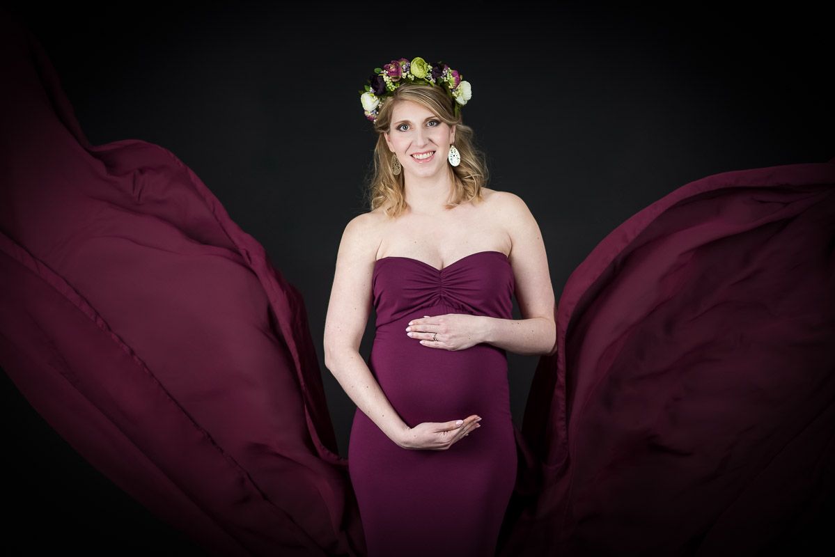 Een gestylde shoot van een mama met bolle buik en een bloemenkroontje in de studio