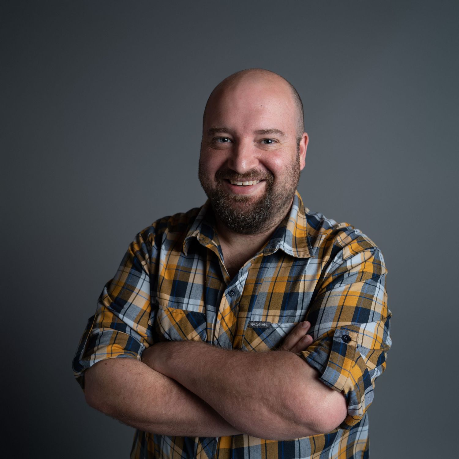 Studio portrait series showing casual poses in yellow plaid shirt against dark background.