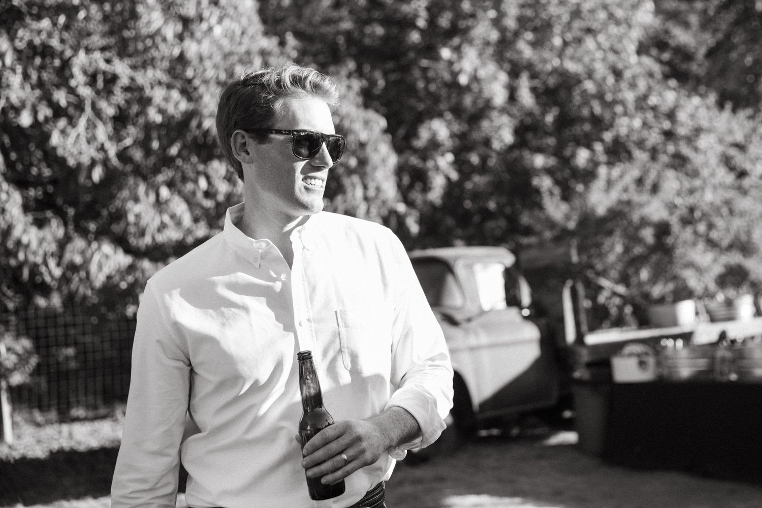 Person in sunglasses and white shirt enjoying an outdoor event.