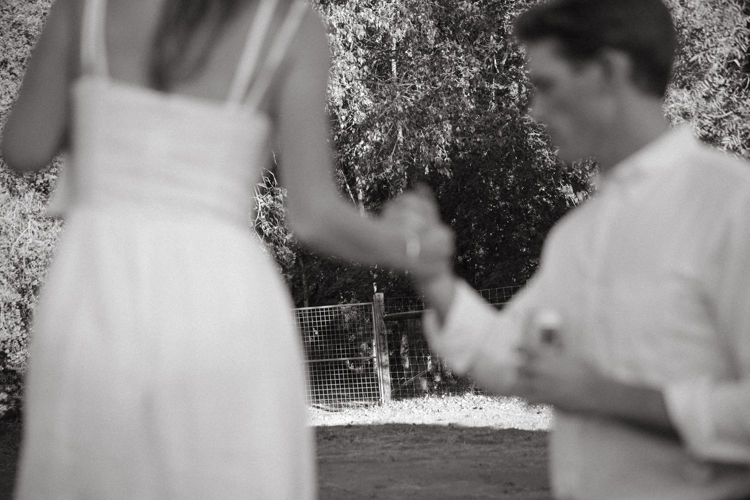 A blurred black and white image of people at an outdoor gathering.