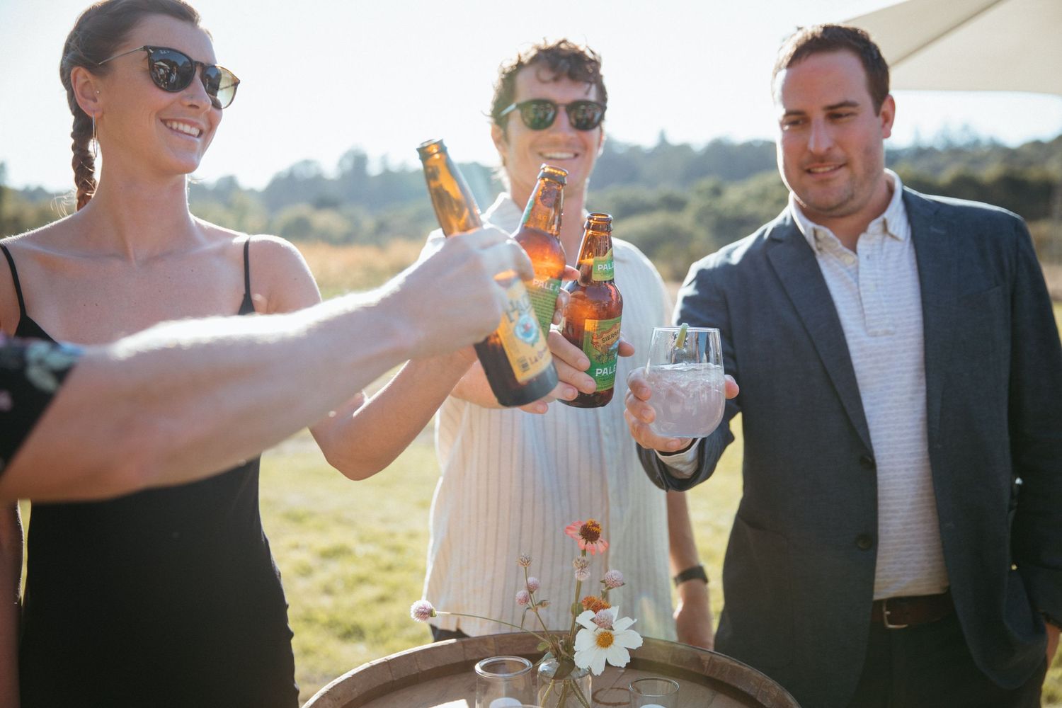 Group toasting with drinks at an outdoor celebration.