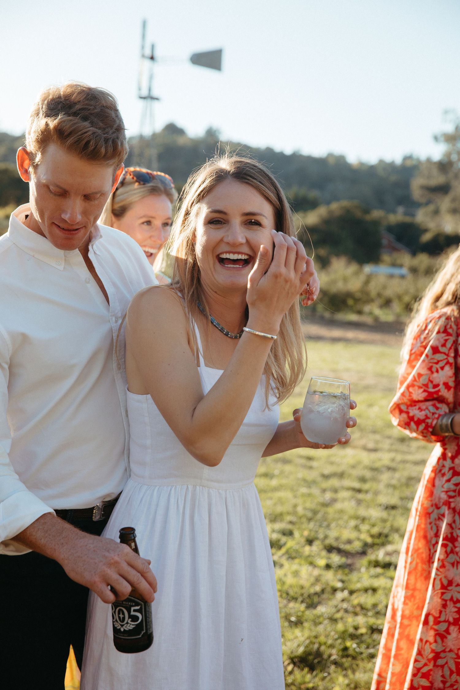 Guests share joyful moments at a sunny outdoor celebration.