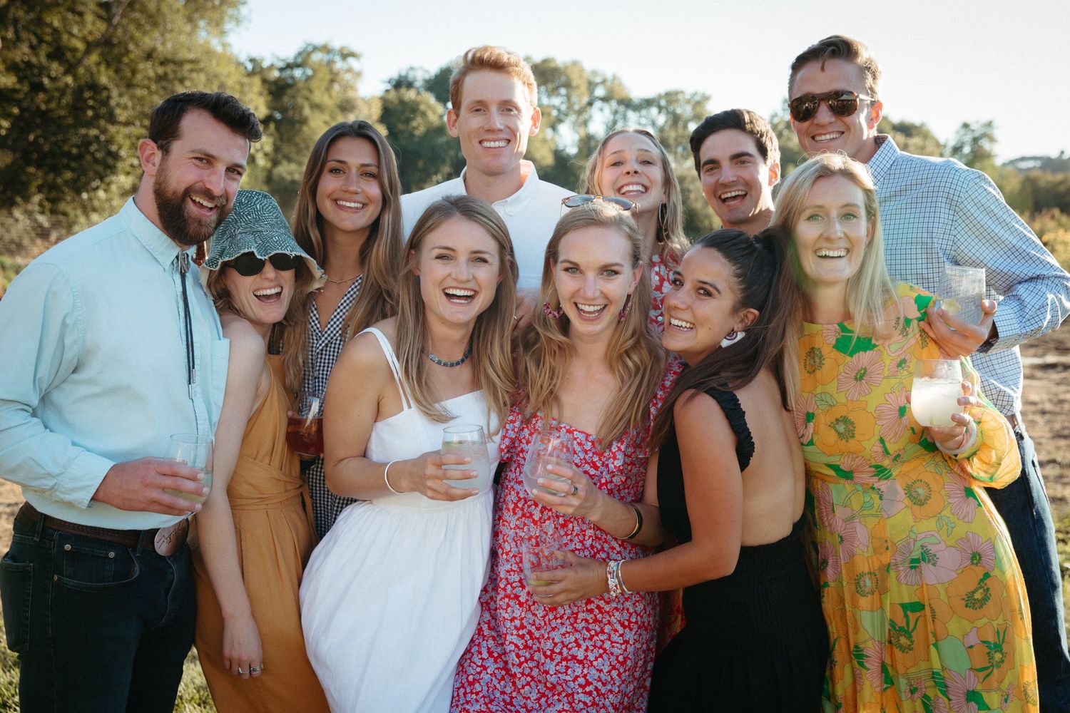 A group of friends pose together at an outdoor summer celebration.