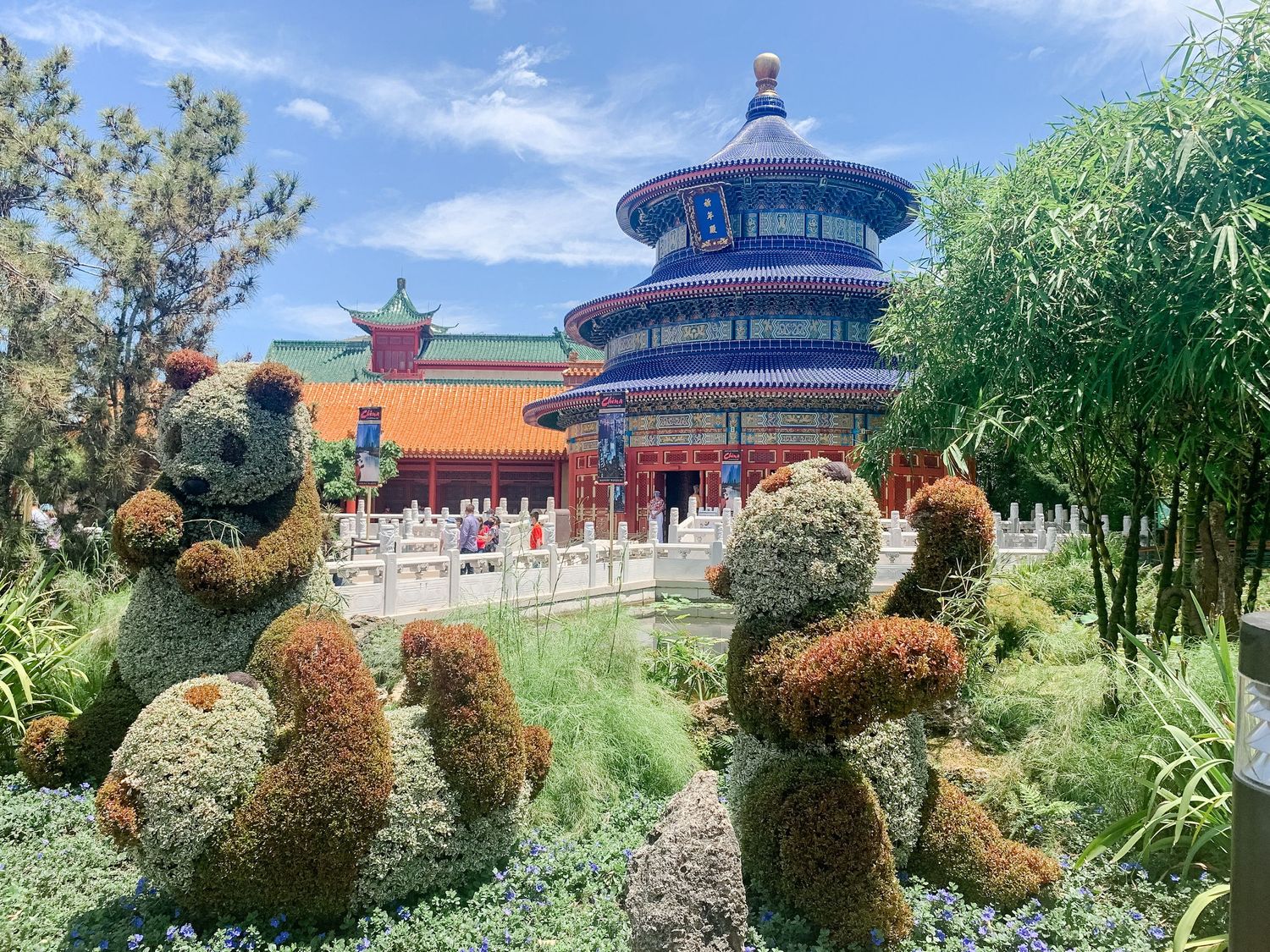 Temple of Heaven replica with topiary gardens featuring Mickey Mouse-shaped bushes in the foreground.