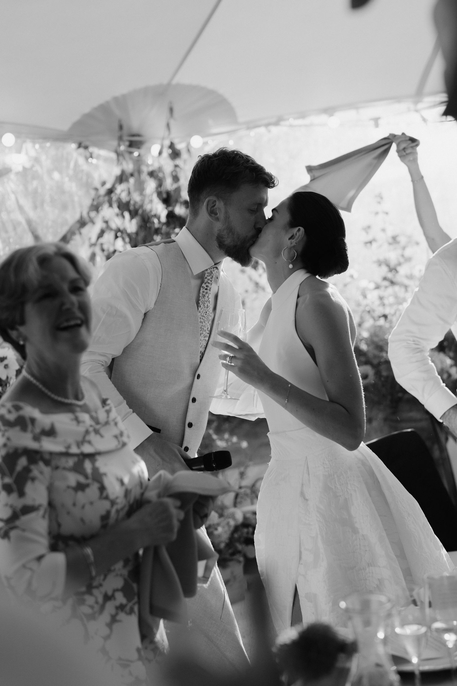 bride and groom kissing after grooms speech at marquee wedding in islip in oxfordshire