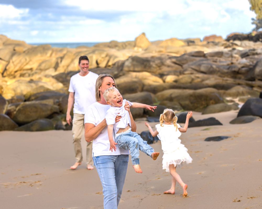 Mother, Father and there 2 kids playing on the beach at Coolum