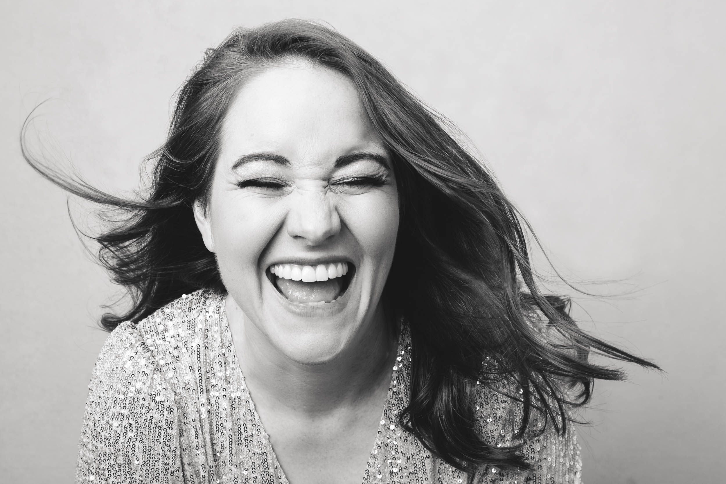 Black and white series showing joyful, candid laughter with hair flowing in the wind.