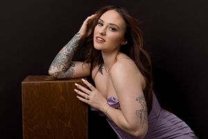 Glamour portrait session featuring purple dress and wooden prop bench.