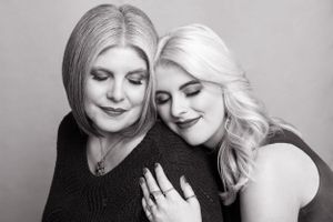 Two women pose intimately in black and white portrait photography series.