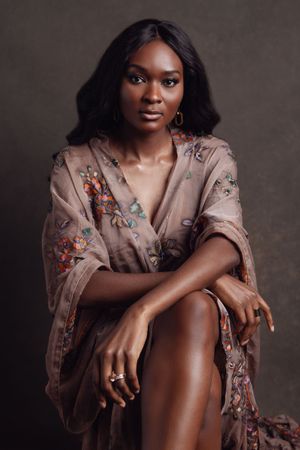 Elegant portrait series featuring a floral robe against dark backdrop with natural poses.