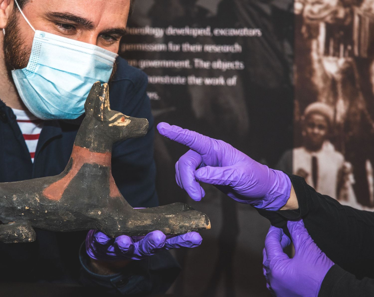 Conservators in protective gear carefully examining historical artifacts.