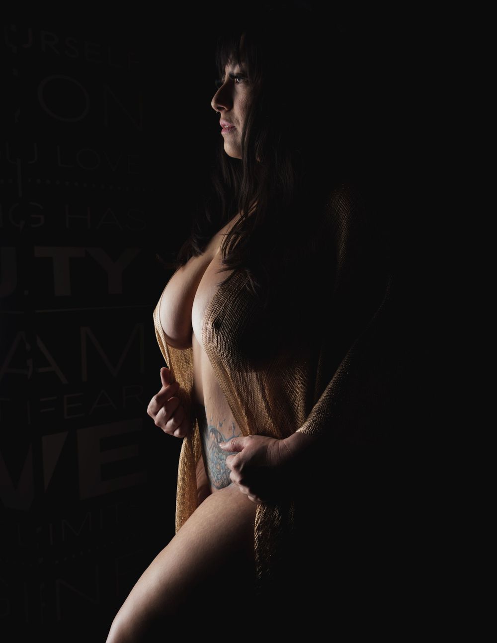 Dark and moody portrait showcasing dramatic shadows and lighting contrasts with a golden shawl.