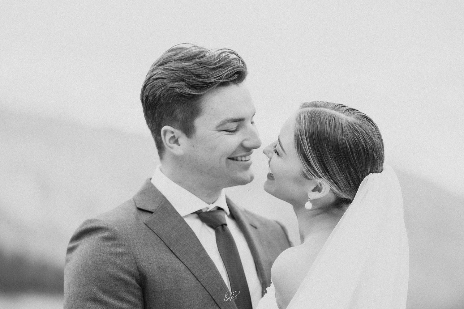 Intimate black and white portrait of wedding couple sharing a romantic moment.