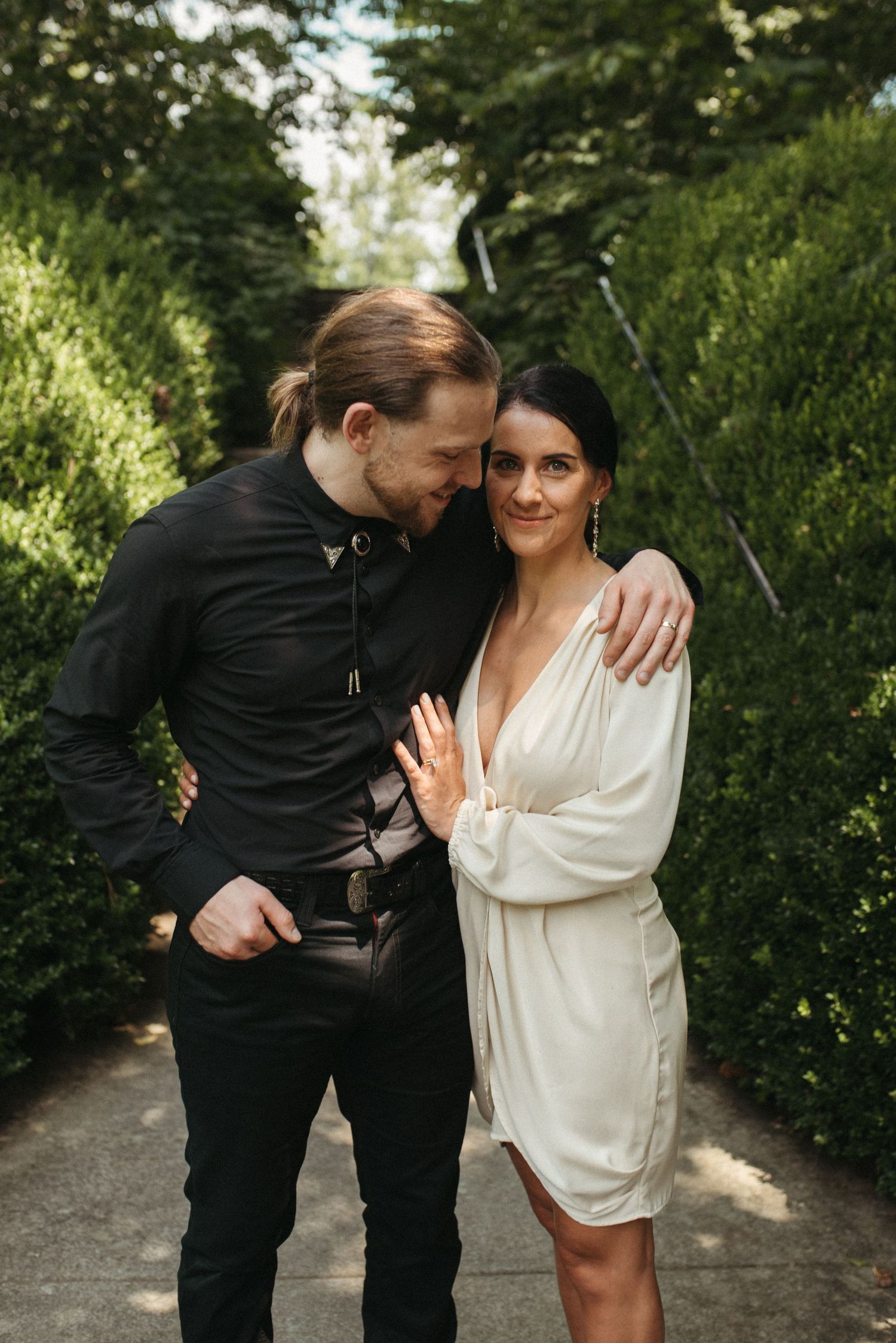 A candid wedding photo showing the couple embracing on a garden path.