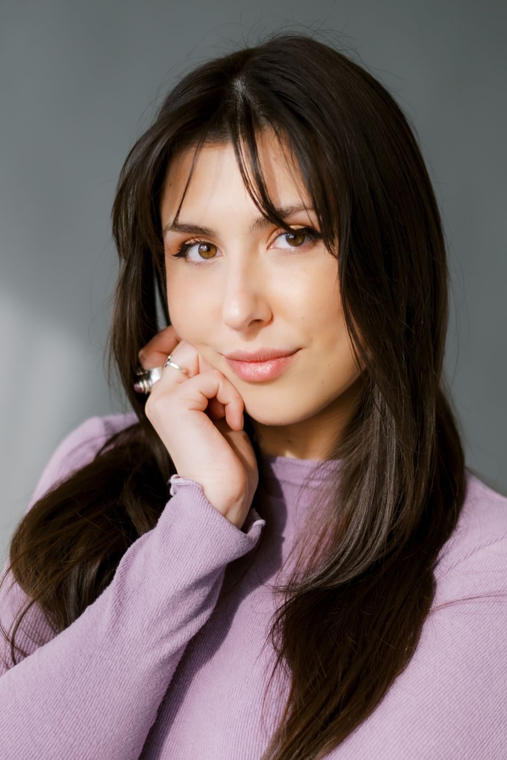 Close-up portrait in lilac sweater with soft studio lighting.