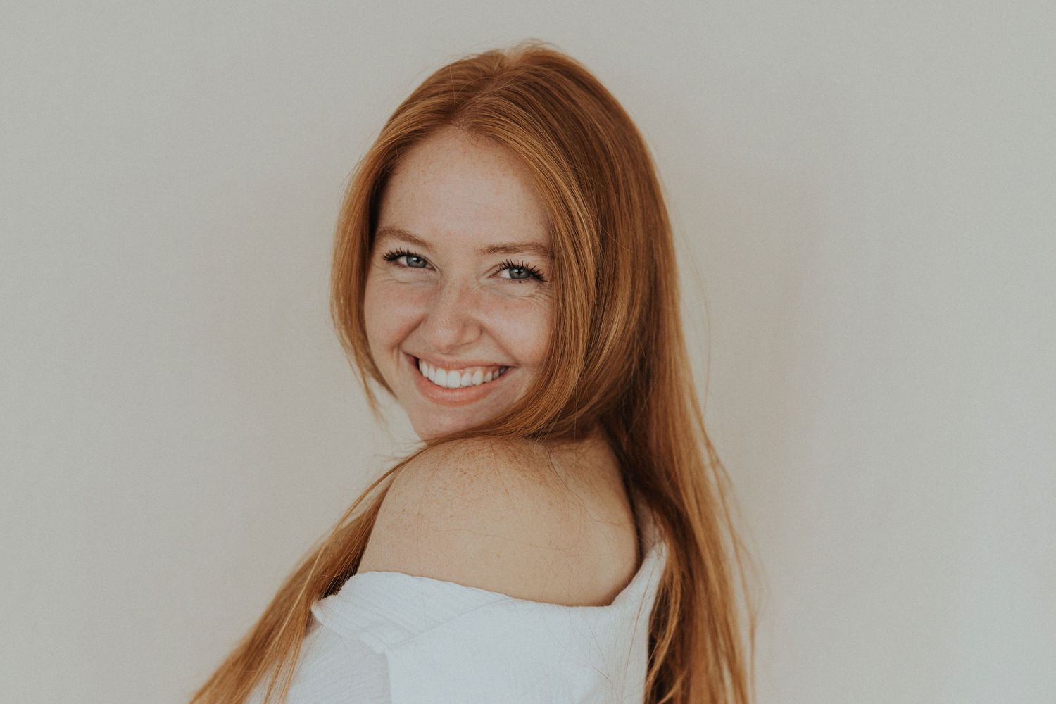 A redhead woman stands and smiles