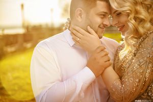 A tender golden hour moment captured between a couple in elegant attire.