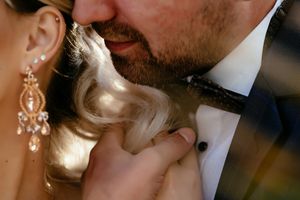 Close-up intimate moment captured with sparkling earring detail and formal attire.