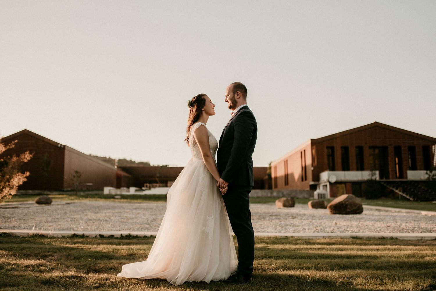 Sunset wedding portrait with rustic buildings and mountain landscape in the background.