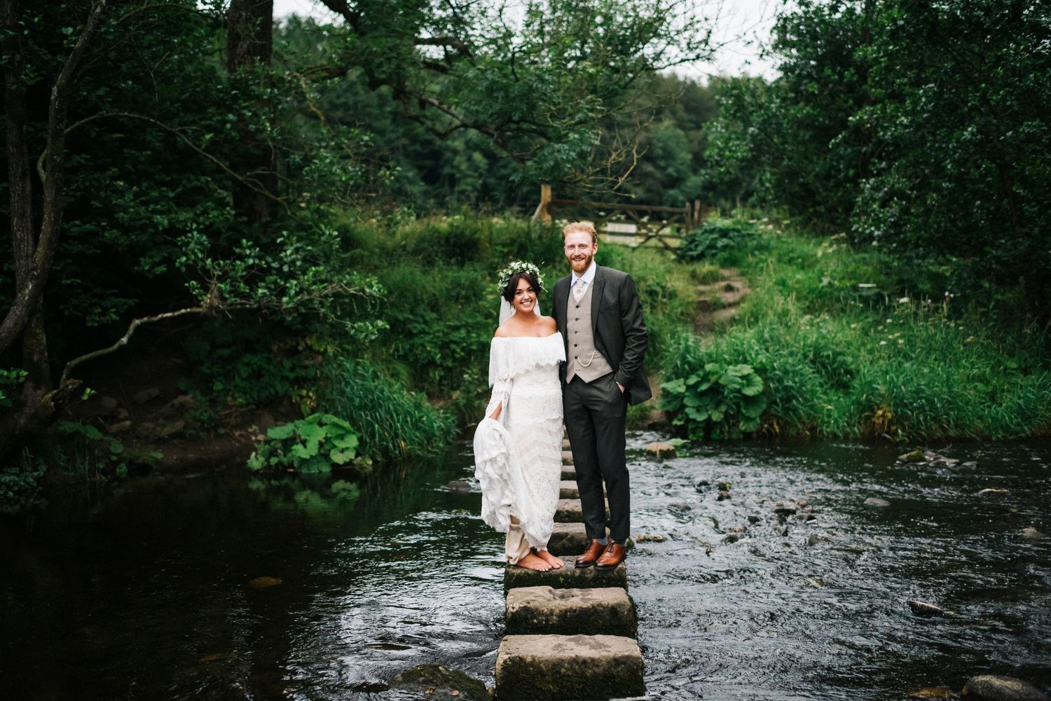 Inn at Whitewell wedding, boho wedding, bride and groom on stepping stones, bride in floral crown, groom in tweed suit