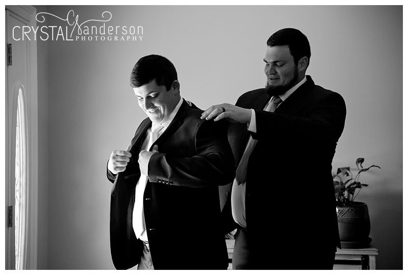 Wedding party members in formal attire posing in black and white.